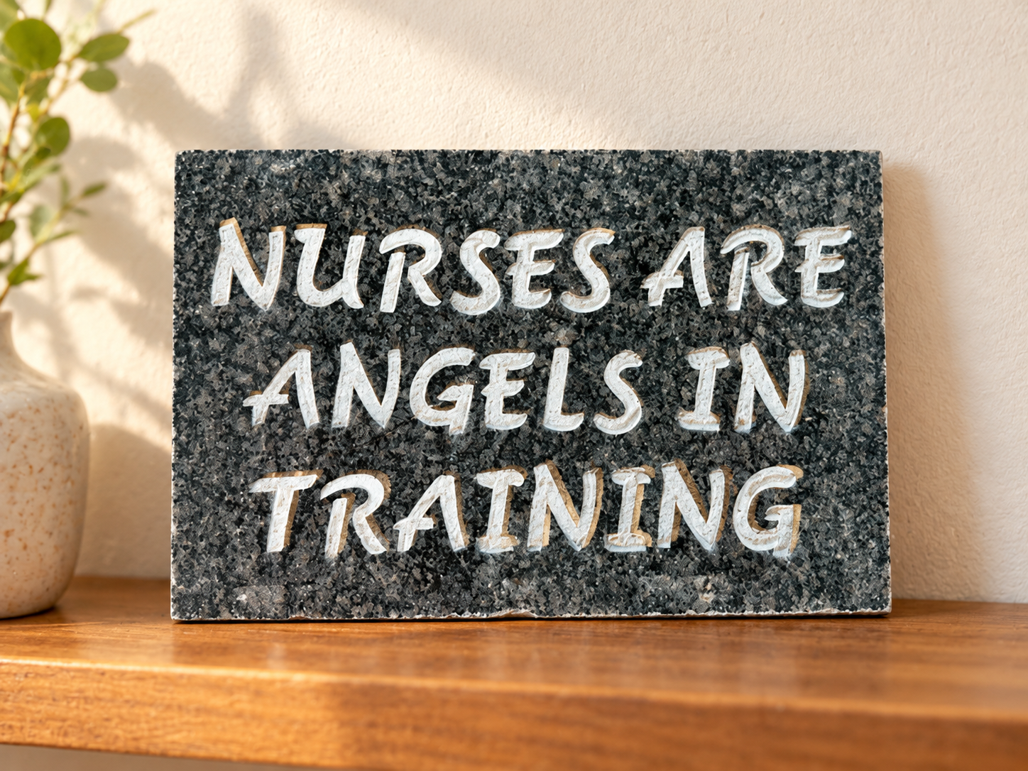Nurses Are Angels in Training displayed on a shelf. Engraving: NURSES ARE / ANGELS IN / TRAINING